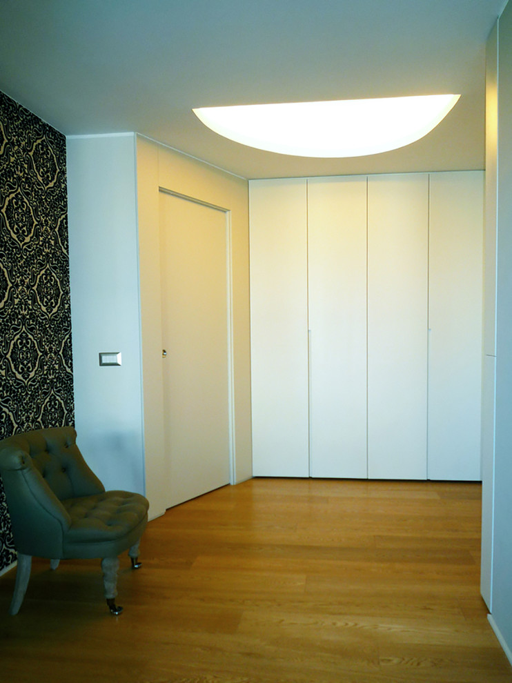 Immagine di un ingresso moderno di medie dimensioni con pareti beige, parquet chiaro, una porta singola, una porta bianca e pavimento beige
