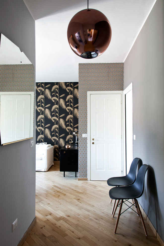 Mittelgroßes Stilmix Foyer mit grauer Wandfarbe, braunem Holzboden, Einzeltür, weißer Haustür und braunem Boden in Mailand