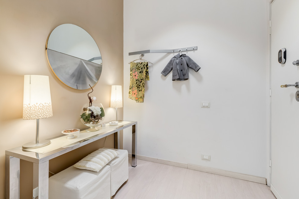 Foto de distribuidor minimalista de tamaño medio con paredes beige, suelo laminado y suelo beige