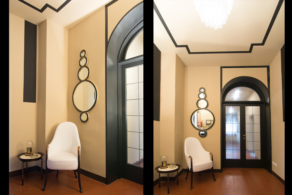 フィレンツェにあるラグジュアリーな広いミッドセンチュリースタイルのおしゃれなマッドルーム (ベージュの壁、テラコッタタイルの床、黒いドア、赤い床、クロスの天井、羽目板の壁) の写真