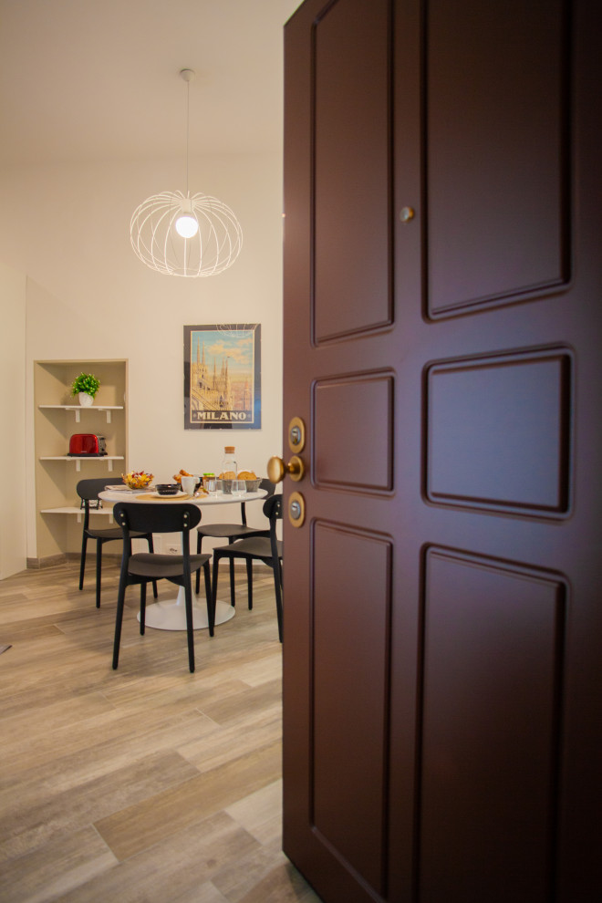 Foto di un piccolo ingresso o corridoio design con pareti bianche, pavimento in gres porcellanato, una porta singola, una porta in legno scuro e pavimento multicolore