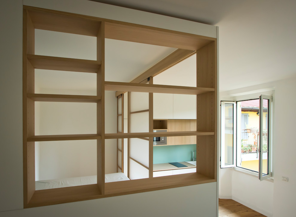 Foto på en liten minimalistisk foajé, med vita väggar, ljust trägolv, en enkeldörr, en vit dörr och brunt golv