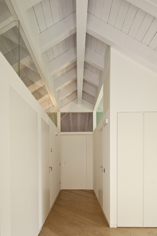 Example of a mid-sized trendy light wood floor and beige floor hallway design in Milan with white walls