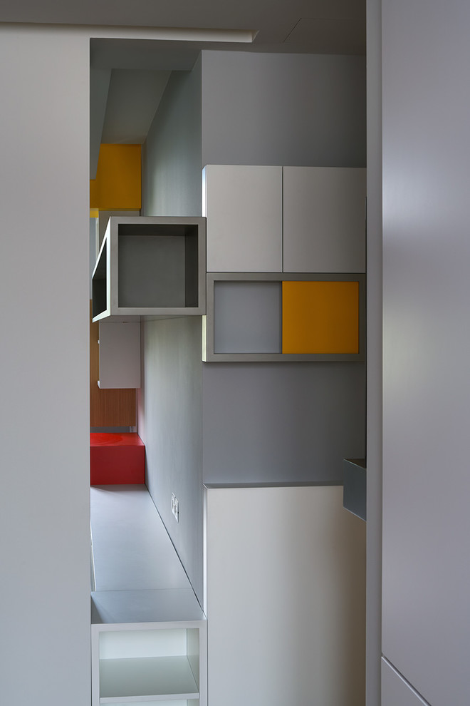 Idée de décoration pour un petit hall d'entrée design avec un mur gris, parquet clair, une porte simple et une porte grise.