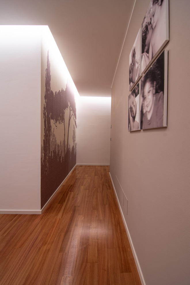 Inspiration pour un grand couloir design avec un mur beige, parquet peint, un sol marron et du papier peint.