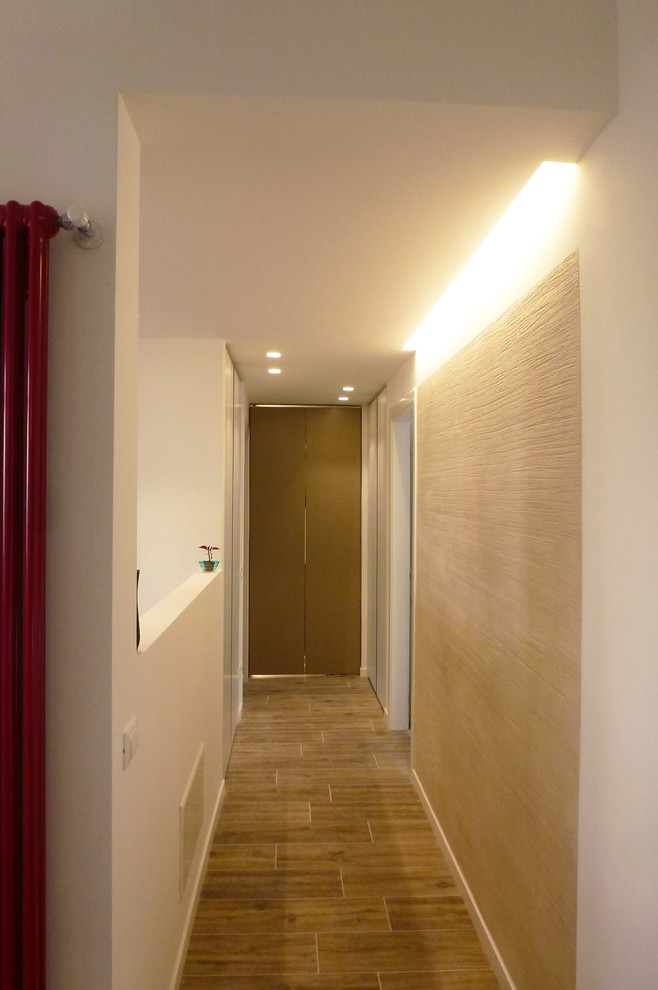 Idee per un ingresso o corridoio design di medie dimensioni con pareti bianche, pavimento in gres porcellanato e pavimento marrone