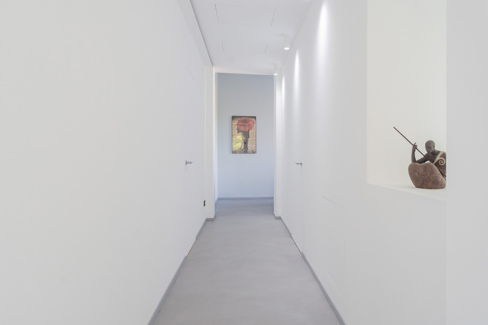 Пример оригинального дизайна: коридор среднего размера в современном стиле с белыми стенами, бетонным полом, серым полом и обоями на стенах