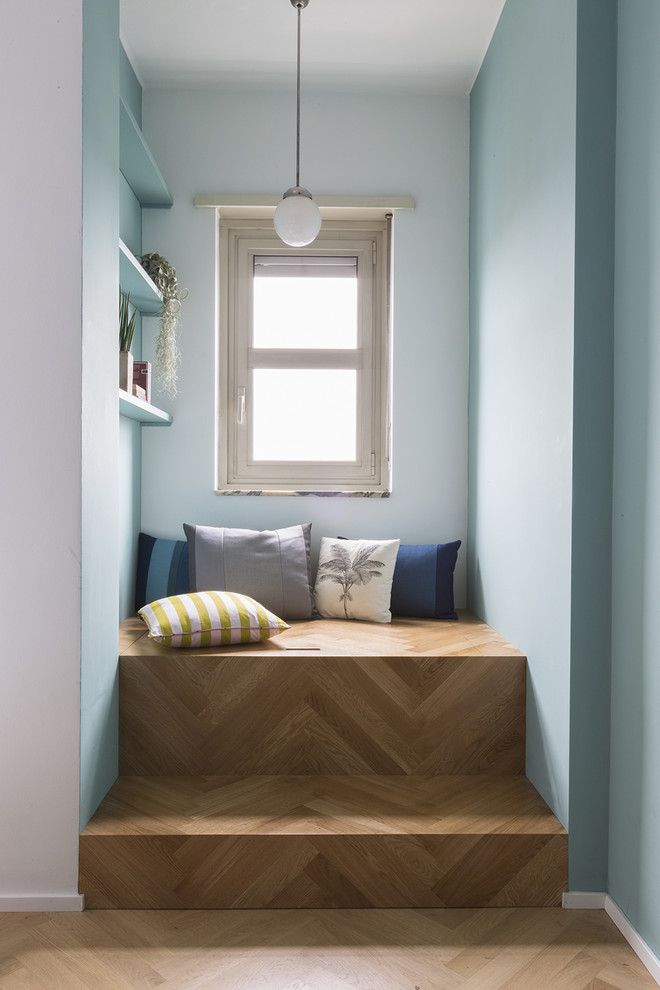 Cette image montre un couloir design avec un mur bleu, un sol en bois brun et un sol marron.