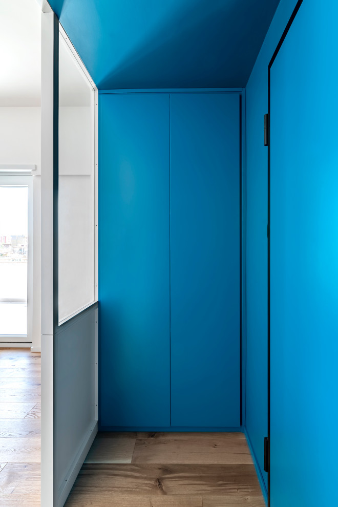 Kleines Nordisches Foyer mit blauer Wandfarbe, hellem Holzboden, Einzeltür, blauer Haustür, eingelassener Decke und Holzwänden in Rom
