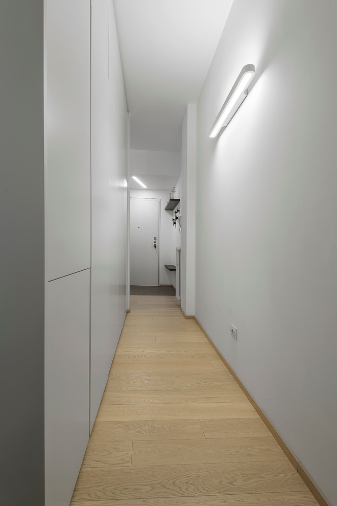 Réalisation d'un couloir design de taille moyenne avec un mur blanc, un sol en carrelage de céramique et un sol beige.