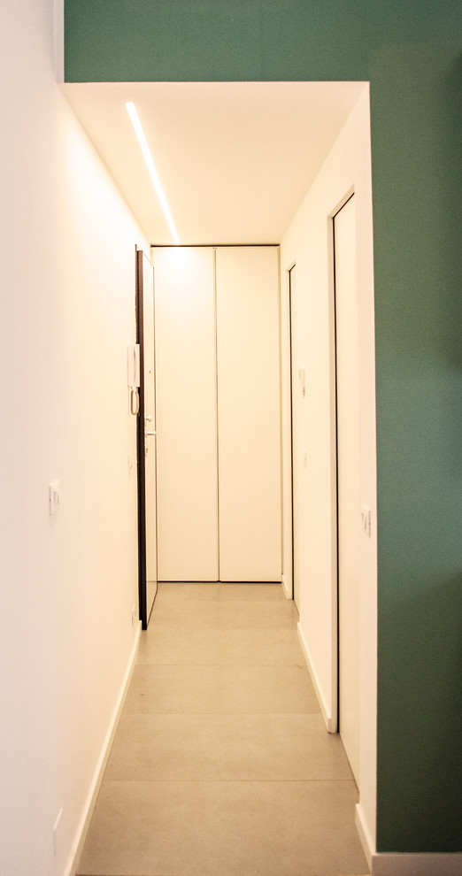 Idée de décoration pour un petit couloir design avec un mur blanc, un sol en carrelage de porcelaine et un sol gris.