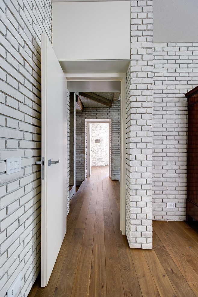 Idee per un grande ingresso o corridoio industriale con pareti bianche e pavimento in legno massello medio