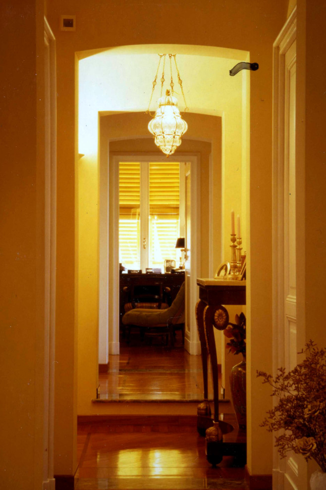 Mittelgroßer Klassischer Flur mit gelber Wandfarbe und dunklem Holzboden in Sonstige