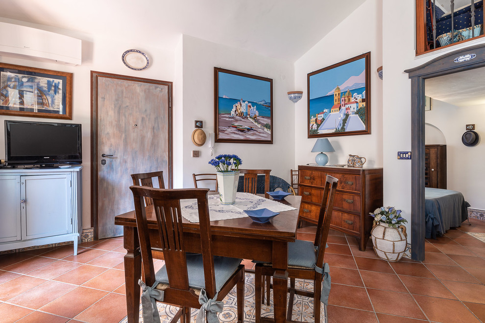 Esempio di una piccola sala da pranzo stile marino con pareti bianche e pavimento marrone