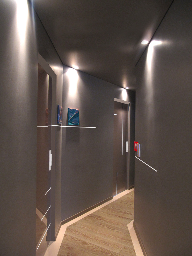Foto di un ingresso o corridoio design di medie dimensioni con pareti marroni, pavimento in legno verniciato e pavimento marrone