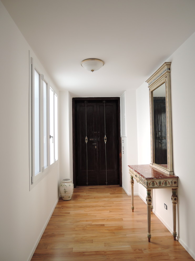 Foto di un grande ingresso design con pareti bianche e pavimento in legno massello medio