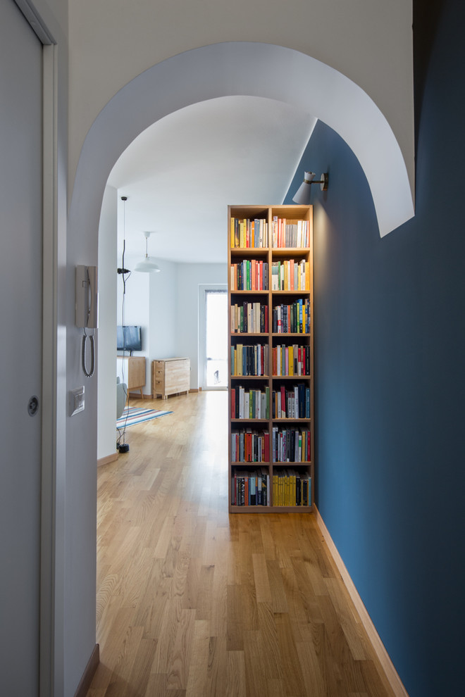 Idée de décoration pour un petit couloir nordique avec un mur bleu et parquet clair.