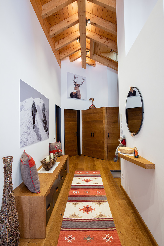 Idee per un ingresso o corridoio stile rurale con pareti bianche e pavimento in legno massello medio