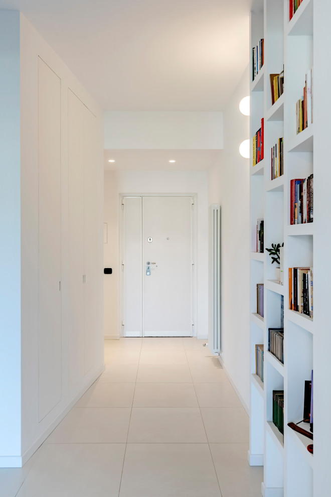 中くらいなコンテンポラリースタイルのおしゃれな玄関ロビー (白い壁、磁器タイルの床、白いドア、ベージュの床、折り上げ天井) の写真