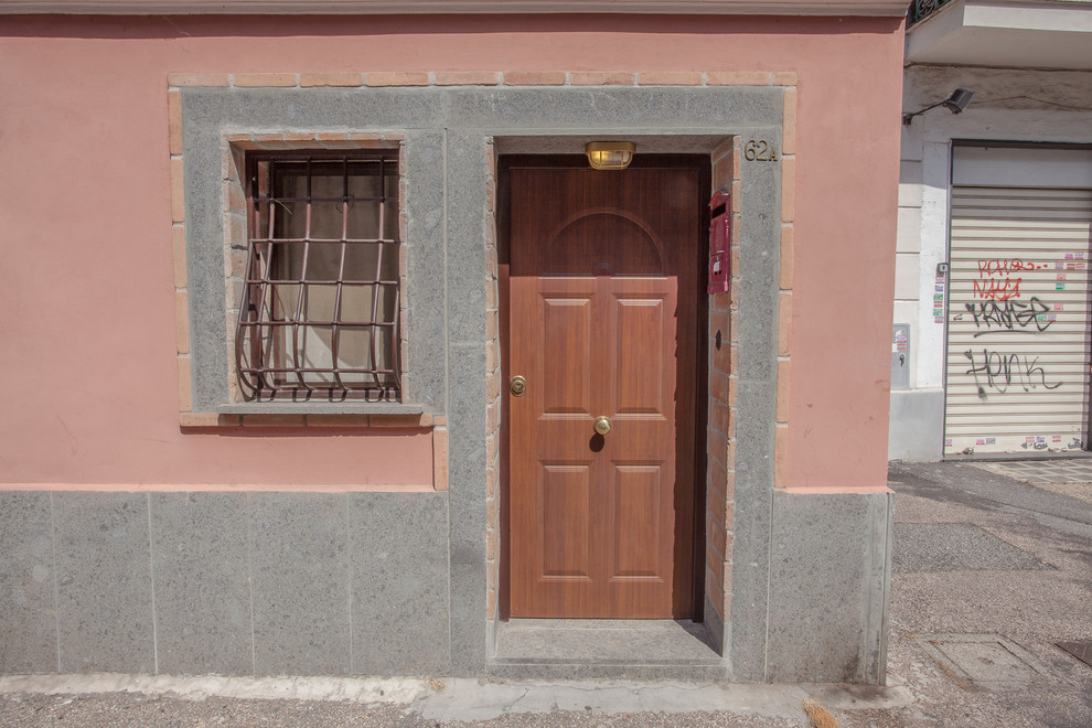 Источник вдохновения для домашнего уюта: маленькая входная дверь в стиле кантри с розовыми стенами, одностворчатой входной дверью и коричневой входной дверью для на участке и в саду