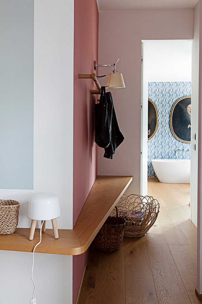 Idée de décoration pour un couloir design de taille moyenne avec un mur multicolore, un sol en bois brun et un sol marron.