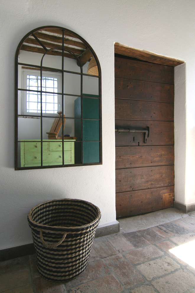 Idee per un piccolo ingresso o corridoio country con pareti bianche, una porta singola e una porta in legno scuro