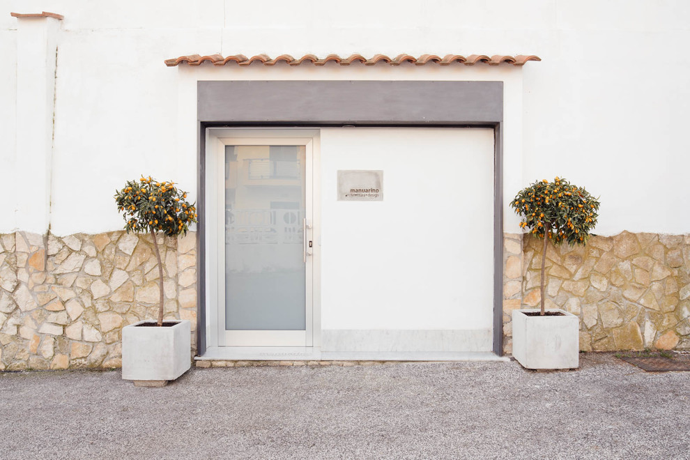 Diseño de entrada mediterránea con paredes blancas, puerta simple y puerta de vidrio
