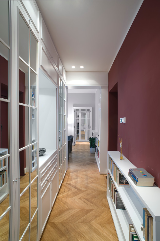 Modelo de recibidores y pasillos tradicionales de tamaño medio con paredes rojas, suelo de madera en tonos medios y suelo marrón