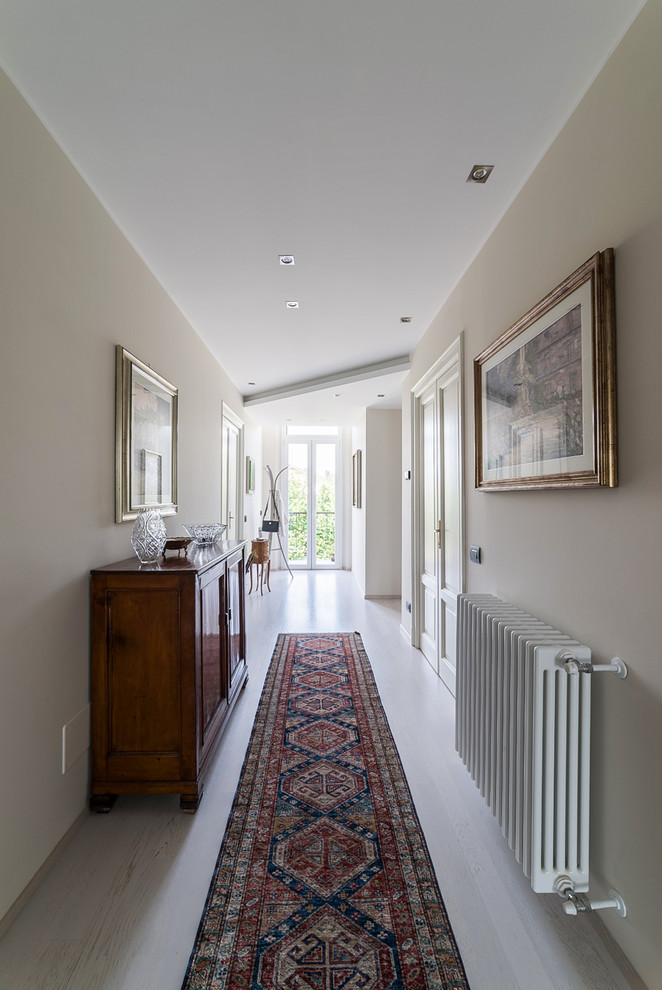 Example of a large classic light wood floor hallway design in Milan with beige walls