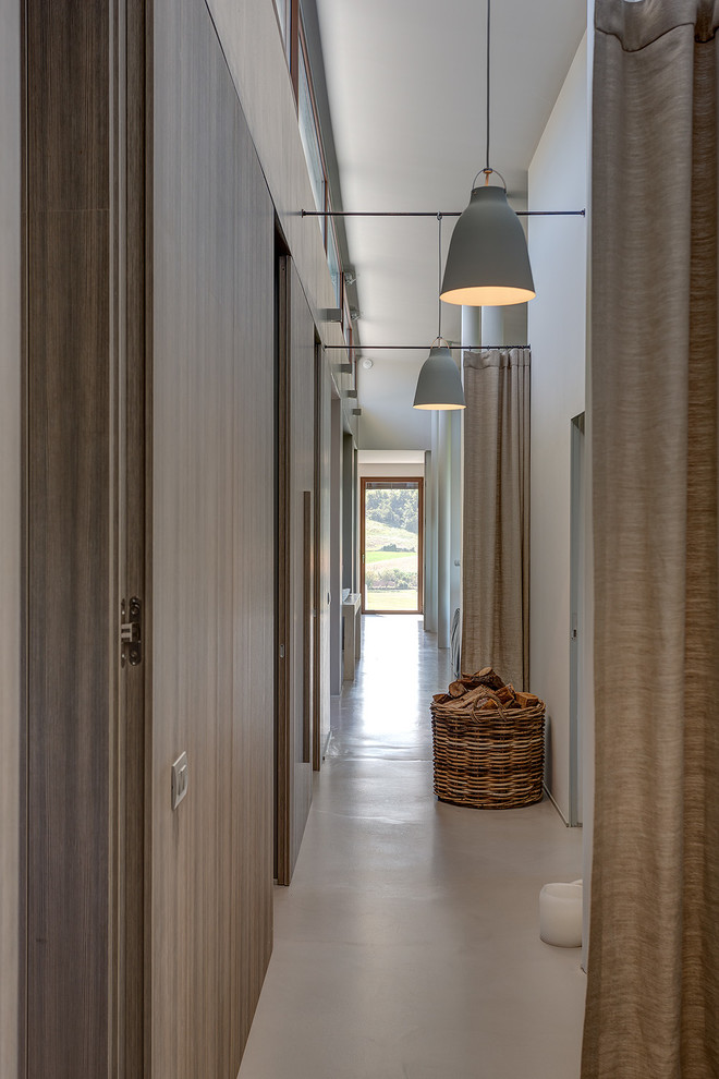 Идея дизайна: большой коридор в стиле кантри с белыми стенами, бетонным полом и серым полом