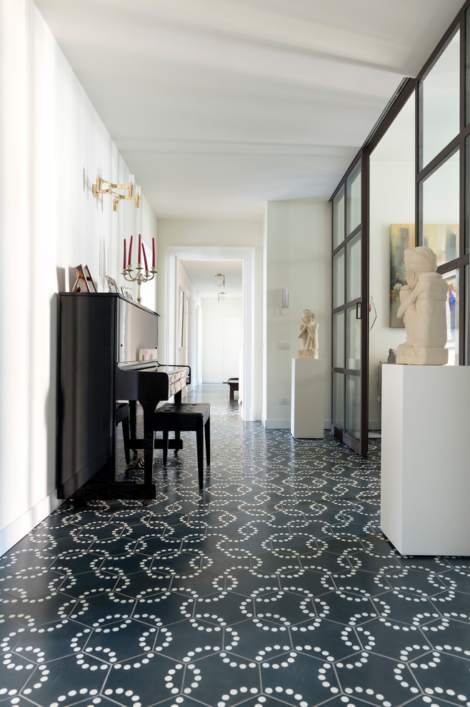 ミラノにある広いトラディショナルスタイルのおしゃれな廊下 (セラミックタイルの床、マルチカラーの床、白い壁) の写真