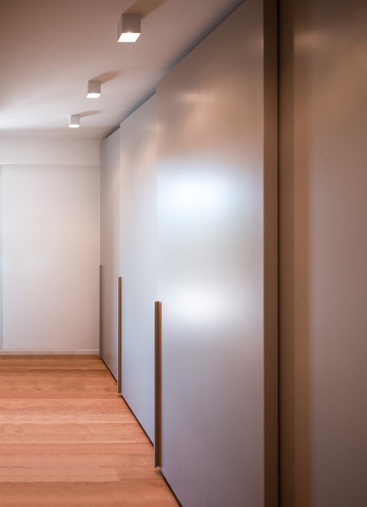 Ispirazione per un ingresso o corridoio contemporaneo di medie dimensioni con pareti bianche, pavimento in legno massello medio e pavimento beige