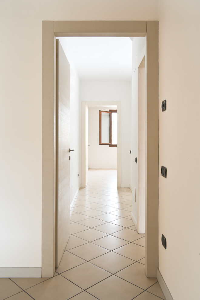 フィレンツェにある低価格の小さなコンテンポラリースタイルのおしゃれな廊下 (白い壁、セラミックタイルの床、ベージュの床) の写真