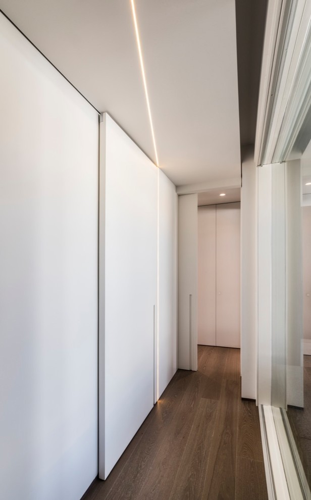 Immagine di un ingresso o corridoio moderno di medie dimensioni con pareti bianche e pavimento in legno verniciato