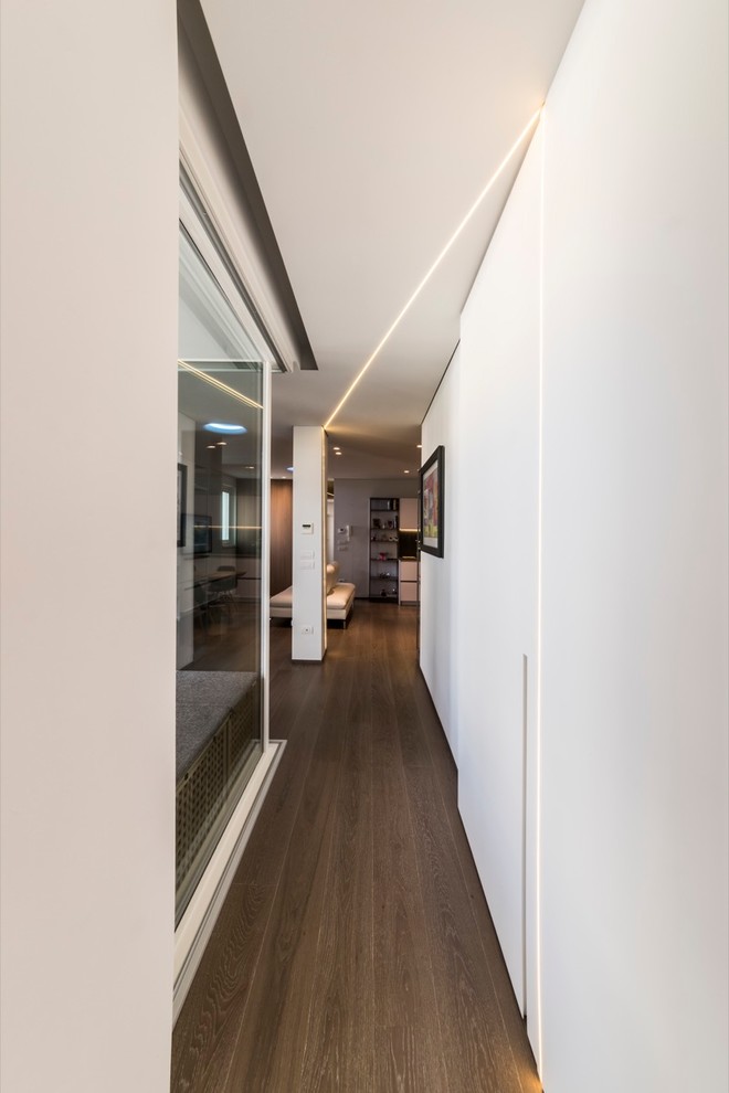 Immagine di un ingresso o corridoio moderno di medie dimensioni con pareti bianche e pavimento in legno verniciato