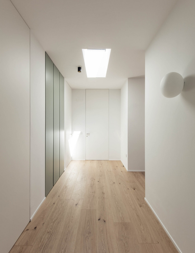 Mid-sized minimalist light wood floor hallway photo in Venice with white walls