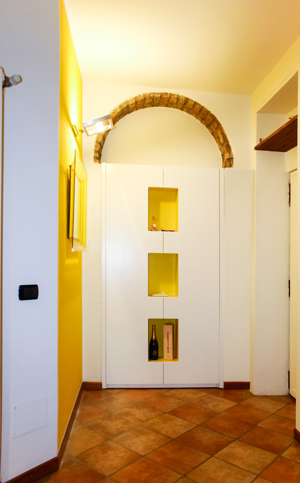Entryway - small modern ceramic tile entryway idea in Milan with yellow walls and a white front door