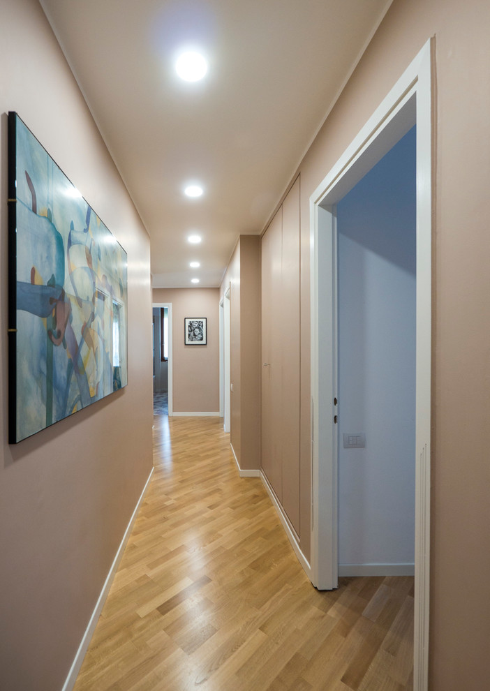 Foto di un ingresso o corridoio minimal di medie dimensioni con pareti beige e parquet chiaro