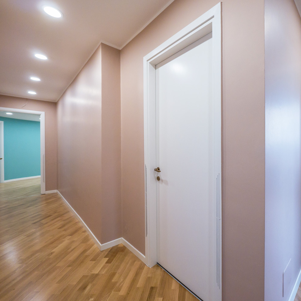 Inspiration for a mid-sized modern light wood floor hallway remodel with beige walls