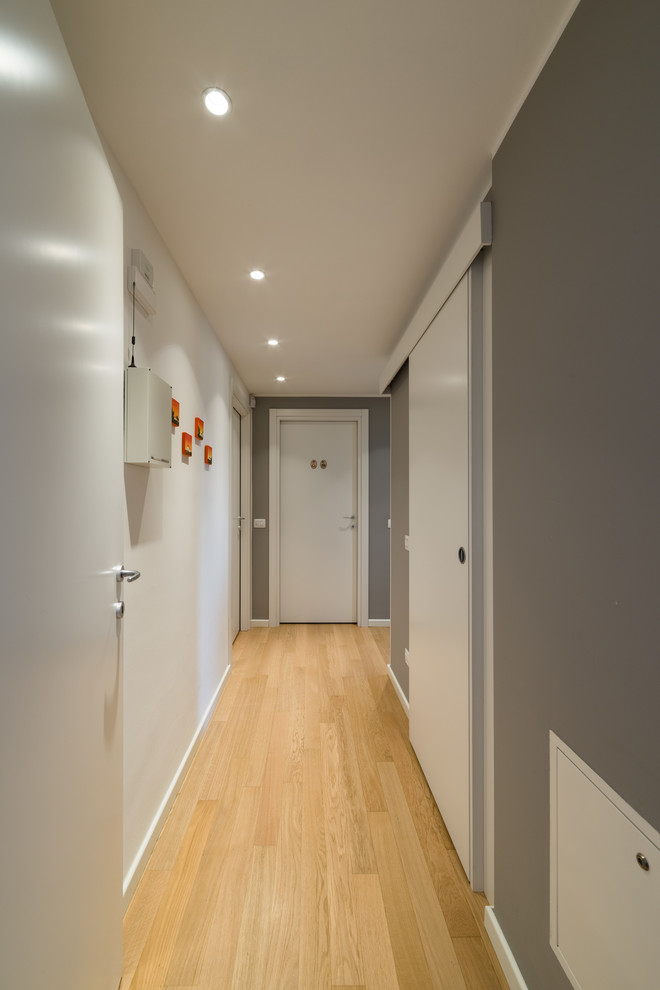 Ispirazione per un piccolo ingresso o corridoio moderno con pareti grigie e parquet chiaro