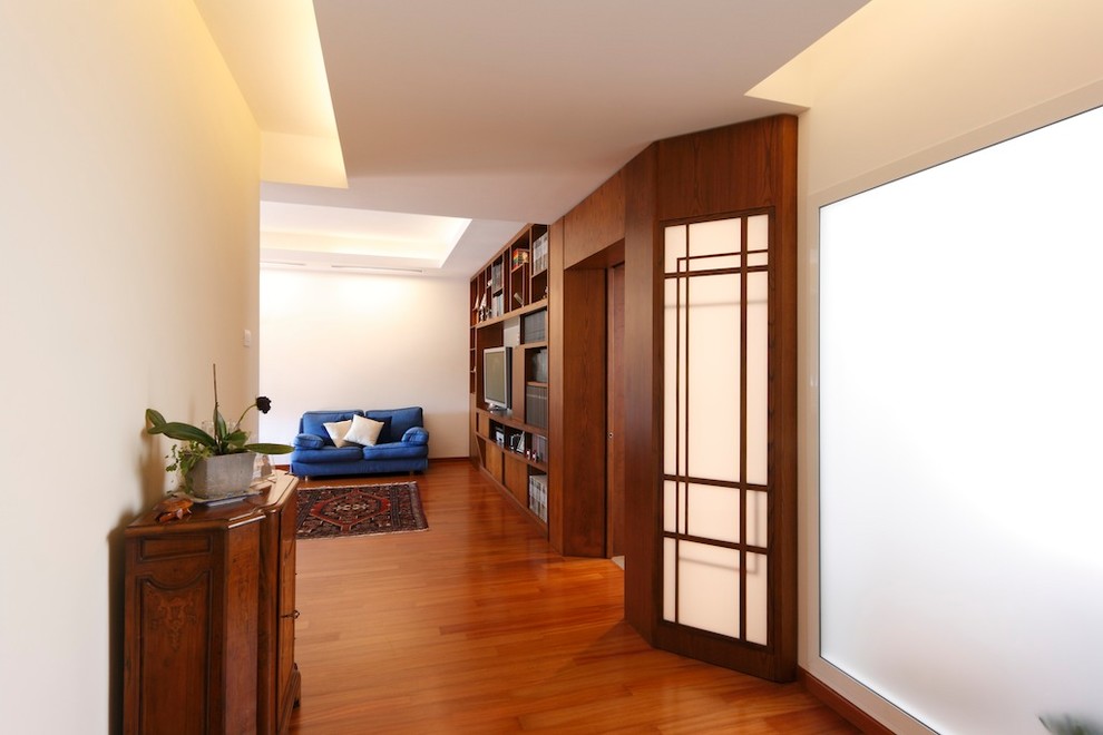 Modernes Foyer mit weißer Wandfarbe, braunem Holzboden und braunem Boden in Rom