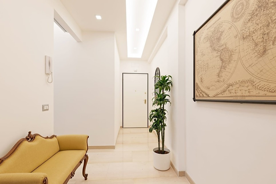 Modelo de hall clásico pequeño con paredes blancas, suelo de mármol, puerta simple, puerta blanca y suelo beige