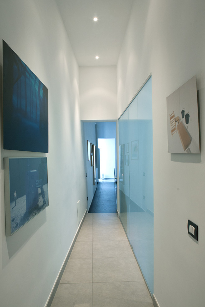 Foto di un piccolo ingresso o corridoio moderno con pareti bianche, pavimento in gres porcellanato e pavimento grigio