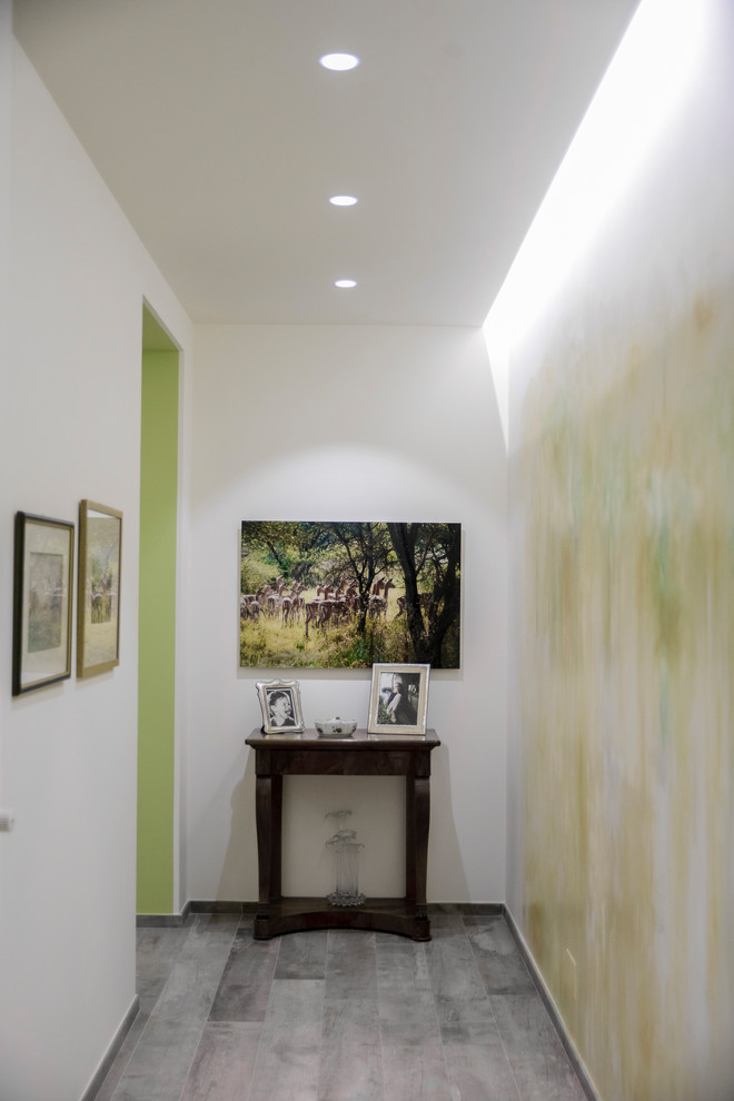 На фото: коридор среднего размера в современном стиле с разноцветными стенами, деревянным полом и коричневым полом