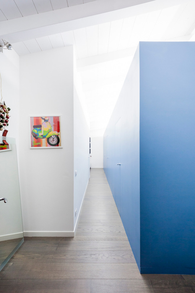 Immagine di un grande ingresso o corridoio minimal con pareti blu e pavimento in legno massello medio