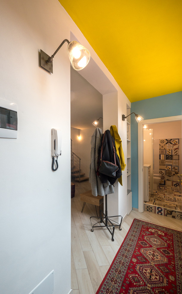Inspiration för små eklektiska hallar, med vita väggar, klinkergolv i porslin, en enkeldörr och en blå dörr