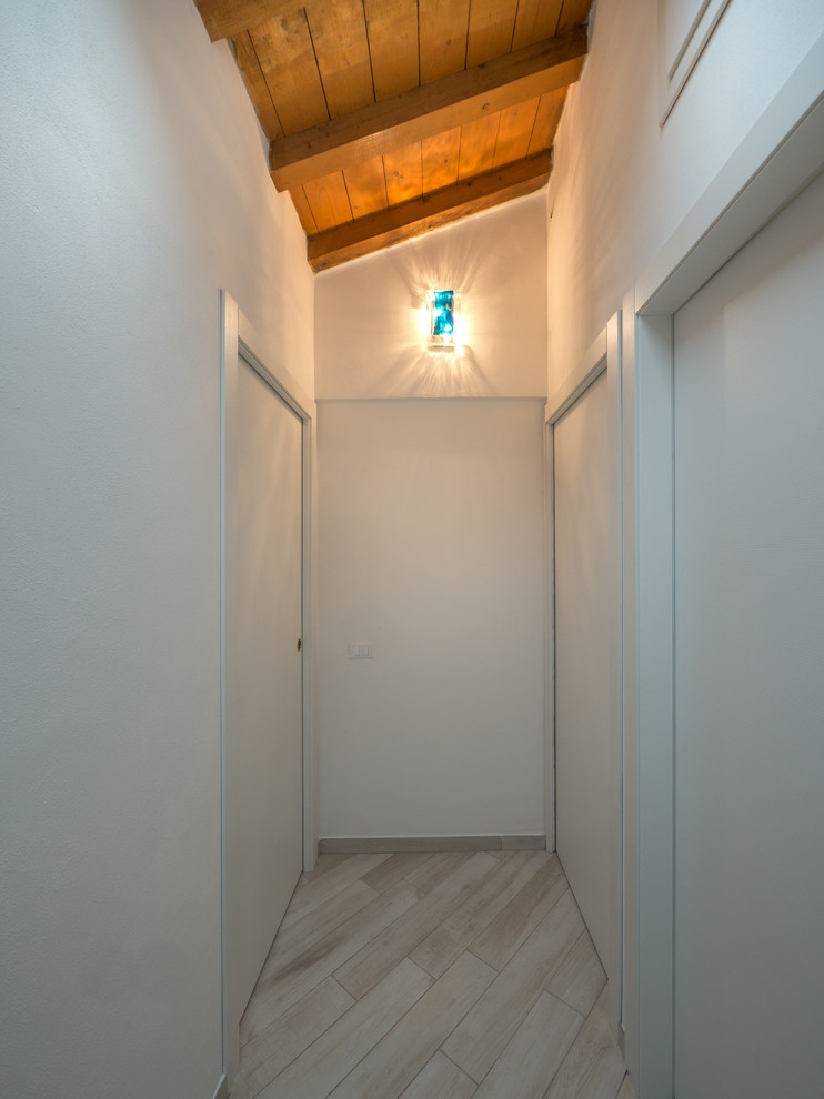 На фото: маленький коридор в стиле фьюжн с белыми стенами и полом из керамогранита для на участке и в саду