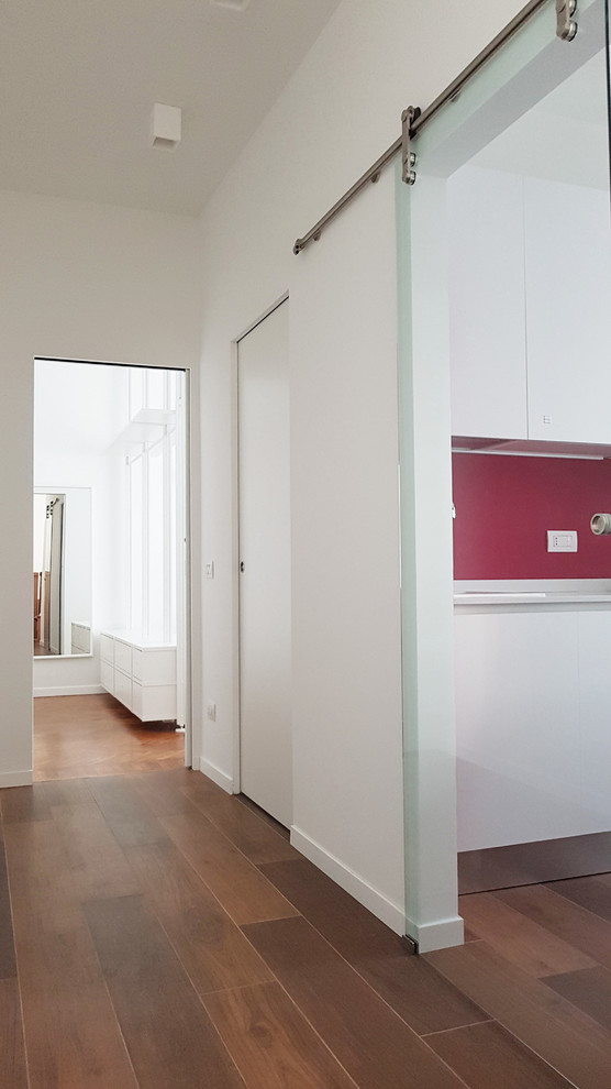 Idee per un piccolo ingresso o corridoio minimal con pareti bianche, pavimento in gres porcellanato e pavimento marrone