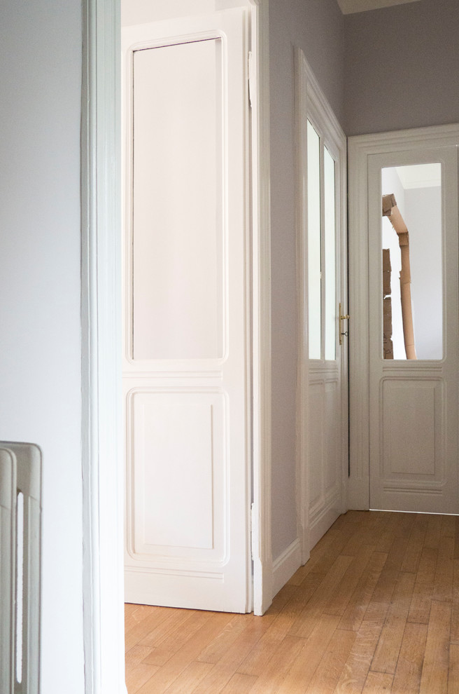 Foto di un ingresso o corridoio minimalista di medie dimensioni con pareti grigie, pavimento in legno verniciato e pavimento beige