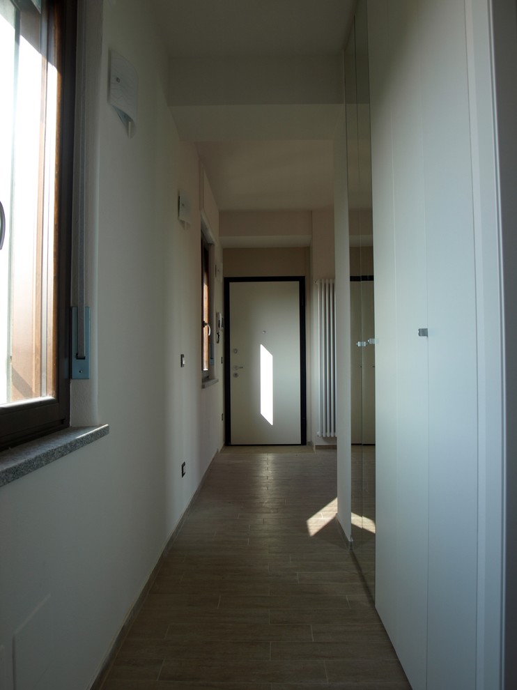 Ejemplo de recibidores y pasillos contemporáneos de tamaño medio con paredes beige, suelo de baldosas de porcelana y suelo beige